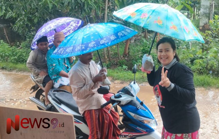 Neli Fitriani, salah satu relawan, saat memberikan nasi bungkus kepada salah seorang warga, @by_News9.id