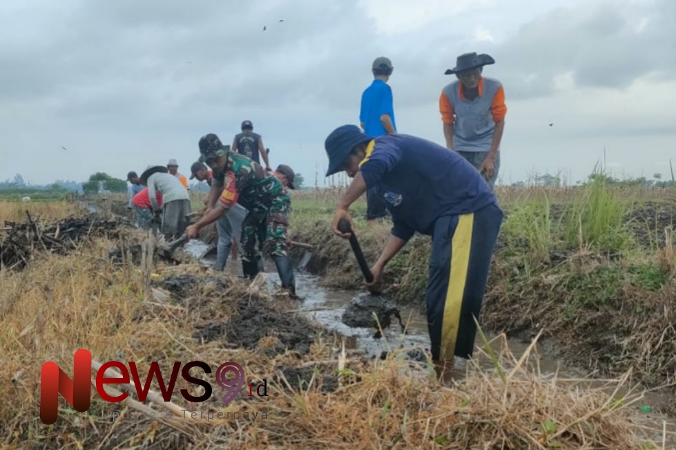 Foto: Sertu Riono Asnan, bersama warga melaksanakan kerja bakti. @by_News9.id