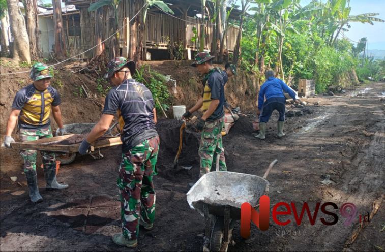Foto: Serma Edy bersama lima personel TNI dan warga setempat melaksanakan pengecoran jalan turunan. @by_News9.id