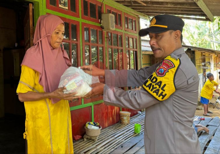 Foto: Kapolsek Kangean IPTU Datun Subagyo, saat menyalurkan bantuan sosial (bansos). @by_News9.id