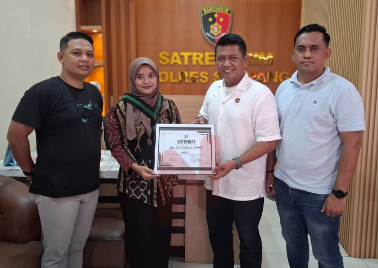 Foto: Usawatun Hasanah saat memberikan penghargaan kepada Kasat Reskrim polres Sampang AKP Safril Selfianto. @by_News9.id