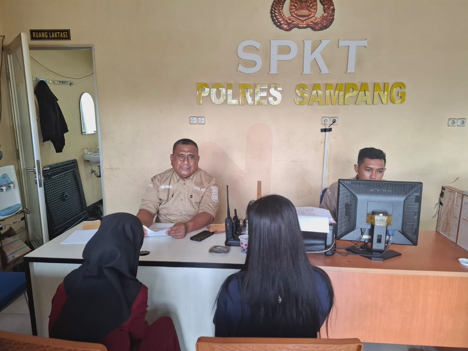 Foto: Aiptu Tohir Purwantoro saat memberikan nasehat kepada TY dan kakak saat mencabut laporan orang hilang diruang SPKT Polres Sampang. @by_News9.id