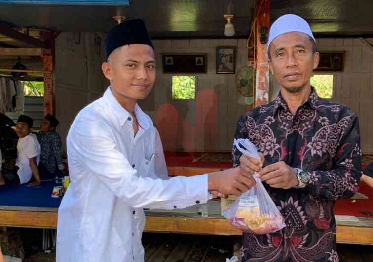 Foto: Ketua PCM Karang Penang, R. Dhahibur Rahman Bahmas saat bagikan ratusan paket daging kurban. @by_News9.id