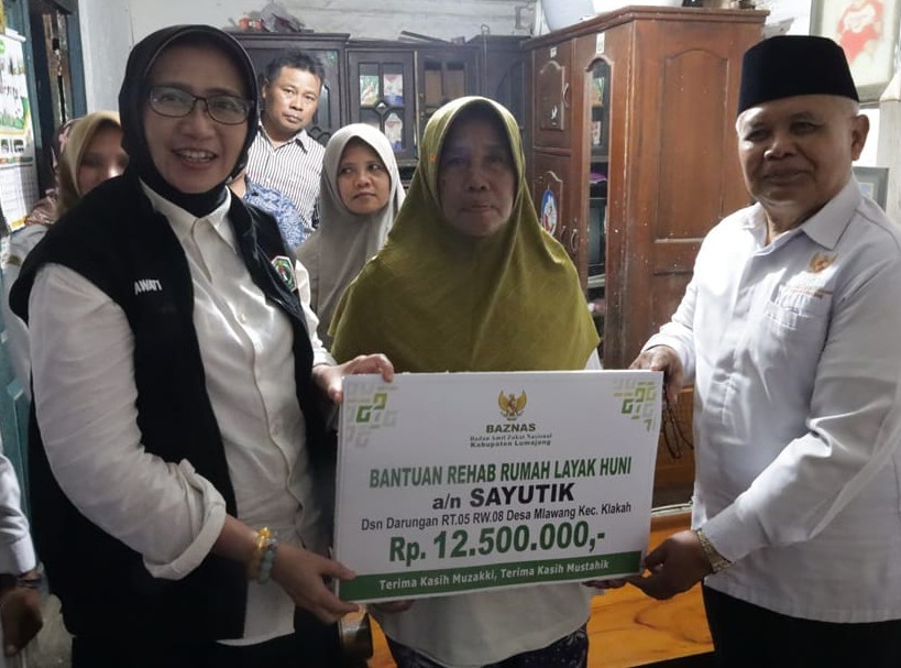FOTO: Bupati Lumajang, Indah Amperawati menyerahkan labgsung bantuan kepada warga. @by_News9.id