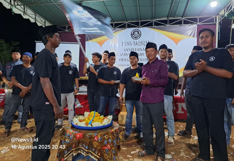 FOTO: Ketua Umum Taruna Muda Pamolokan, Darmawan Susanto (kiri), didampingi ketua pelaksana, Misdaifal (kanan), saat pemotongan dan pemberian tumpeng kepada Pj. Kepala Desa Pamolokan, Ahmad Sayadi (tengah). @by_News9.id