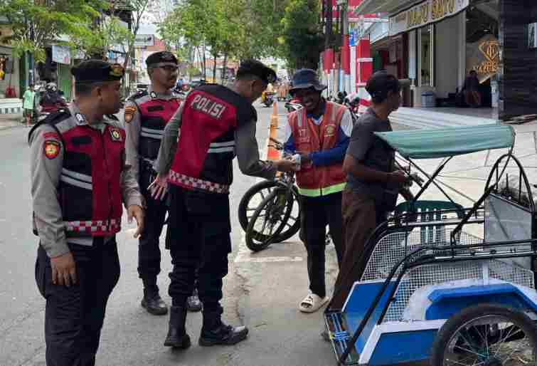 Patroli Bersepeda Polisi Sampang Bagikan Makanan ke Warga Kurang Mampu