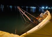 Kapal Pengangkut Batang Kayu Jati Miring di Pelabuhan Kalianget