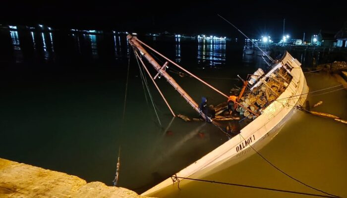 Kapal Pengangkut Batang Kayu Jati Miring di Pelabuhan Kalianget