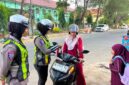 FOTO: Anggota Satlantas Polresta Sumenep saat memberikan bendera Merah Putih kepada pengendara. @by_News9.id