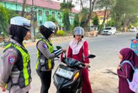 FOTO: Anggota Satlantas Polresta Sumenep saat memberikan bendera Merah Putih kepada pengendara. @by_News9.id