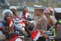 FOTO: Satuan Lalu Lintas (Satlantas) Polres Sampang saat membagikan bendera merah putih. @by_News9.id