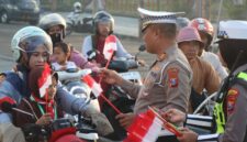 FOTO: Satuan Lalu Lintas (Satlantas) Polres Sampang saat membagikan bendera merah putih. @by_News9.id