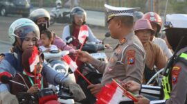 FOTO: Satuan Lalu Lintas (Satlantas) Polres Sampang saat membagikan bendera merah putih. @by_News9.id