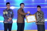 FOTO: Wakil Bupati Sumenep KH. Imam Hasyim saat menerima penghargaan Juara 1 dalam ajang Syariah Award Jawa Timur 2026. @by_News9.id
