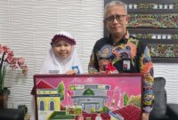 FOTO: Ana Syifaul Millah, siswi kelas VI SDIT Al Hidayah Sumenep bersama Direktur BPRS Bhakti Sumekar. @by_News9.id