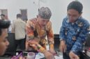 FOTO: Kepala Desa Pangarangan, Miskun Legiyono, saat menandatangani catatan bahwa bangunan Koperasi Merah Putih tersebut belum layak. @by_News9.id