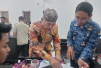 FOTO: Kepala Desa Pangarangan, Miskun Legiyono, saat menandatangani catatan bahwa bangunan Koperasi Merah Putih tersebut belum layak. @by_News9.id