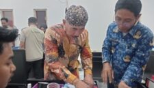 FOTO: Kepala Desa Pangarangan, Miskun Legiyono, saat menandatangani catatan bahwa bangunan Koperasi Merah Putih tersebut belum layak. @by_News9.id