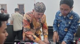 FOTO: Kepala Desa Pangarangan, Miskun Legiyono, saat menandatangani catatan bahwa bangunan Koperasi Merah Putih tersebut belum layak. @by_News9.id