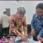 FOTO: Kepala Desa Pangarangan, Miskun Legiyono, saat menandatangani catatan bahwa bangunan Koperasi Merah Putih tersebut belum layak. @by_News9.id